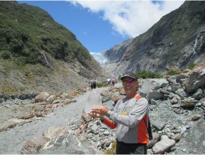 Rocky holding ice from Franz Josef Glacier in the background.